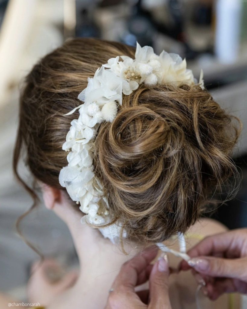 Coiffure de mariée relevée avec couronne en fleurs séchées blanches lors des préparatifs - Les pensées de Lily
