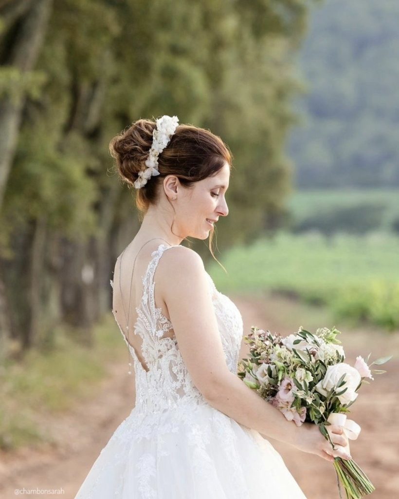 Mariée en robe brodée tenant un bouquet pastel, coiffée d’une couronne en fleurs stabilisées - Les pensées de Lily