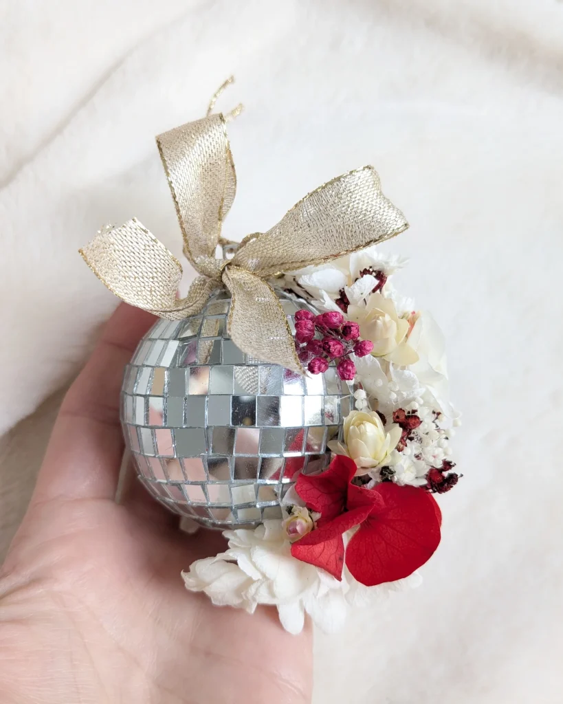 Boule à facettes tenue à la main, ornée d’un nœud doré et de fleurs séchées - Les pensées de Lily
