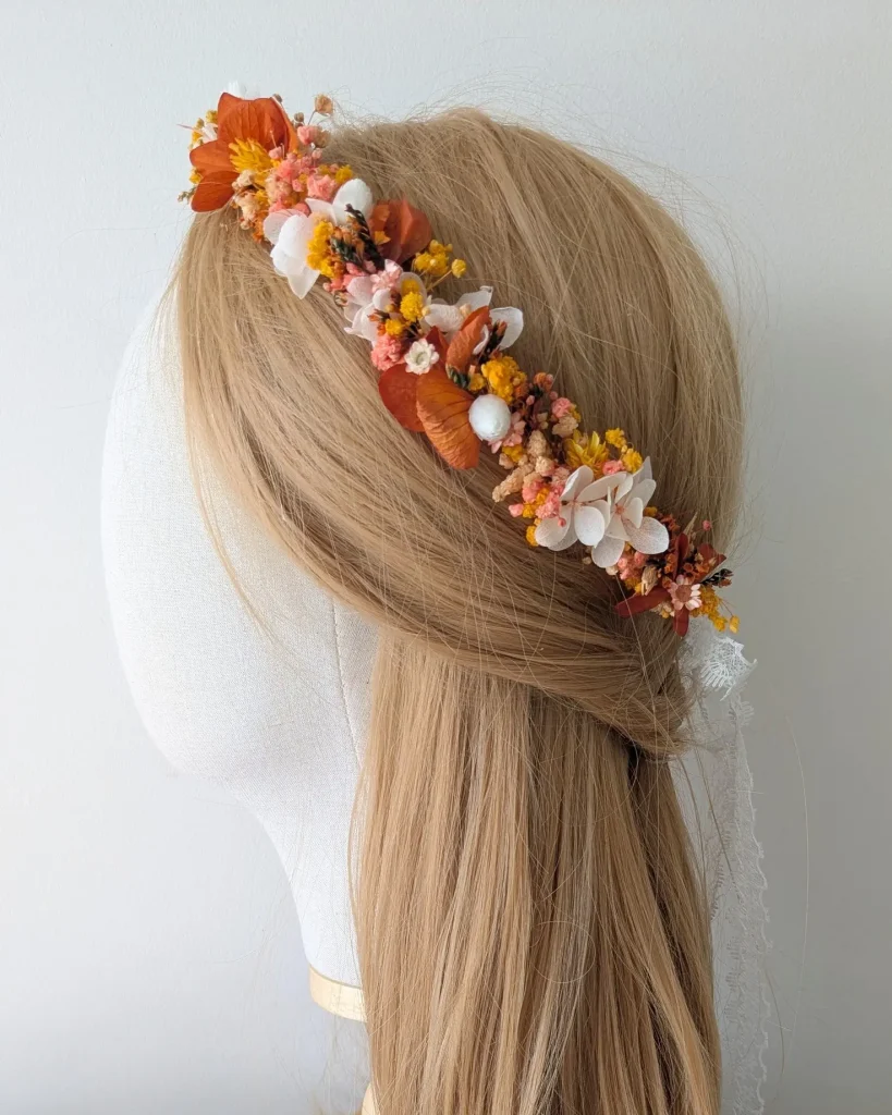 Couronne de tête en fleurs séchées oranges, jaunes et blanches, posée sur un mannequin à la chevelure blonde – Les pensées de Lily