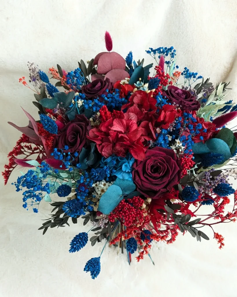 Bouquet de fleurs séchées aux couleurs bordeaux, bleu électrique et touches de vert, composé de roses stabilisées, hortensias et feuillages variés – Les pensées de Lily.
