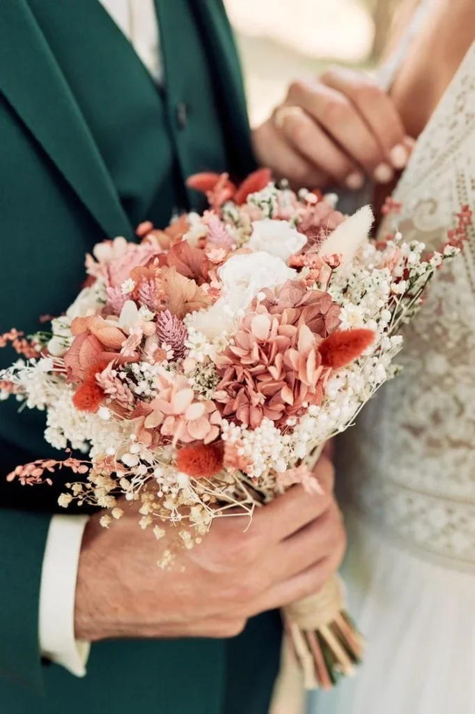 Bouquet de fleurs séchées dans les tons rose, blanc et terracotta tenu par les mariés - Les pensées de Lily
