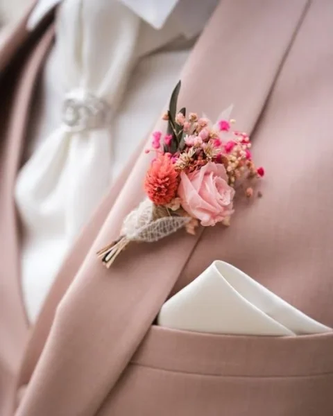 Détail de costume rose poudré avec boutonnière en fleurs séchées rose, corail et gypsophile - Les pensées de Lily