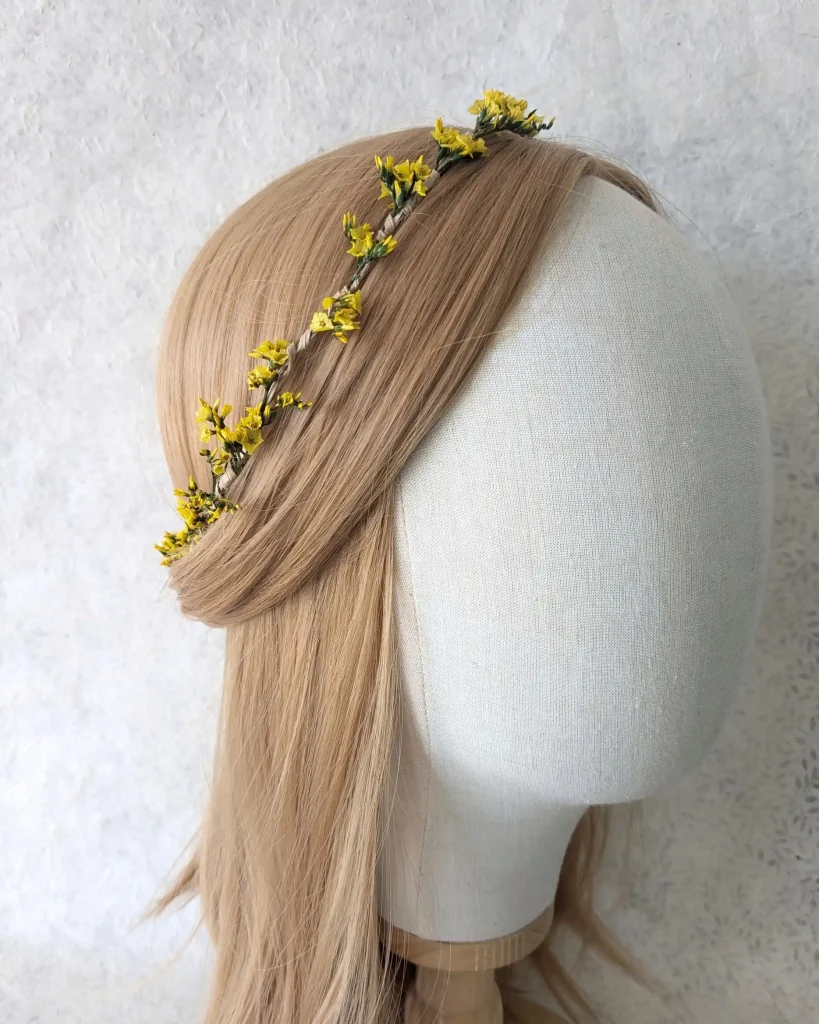 Couronne minimaliste en fleurs séchées jaunes et feuillage vert, présentée sur mannequin, vue de trois-quarts – Les pensées de Lily