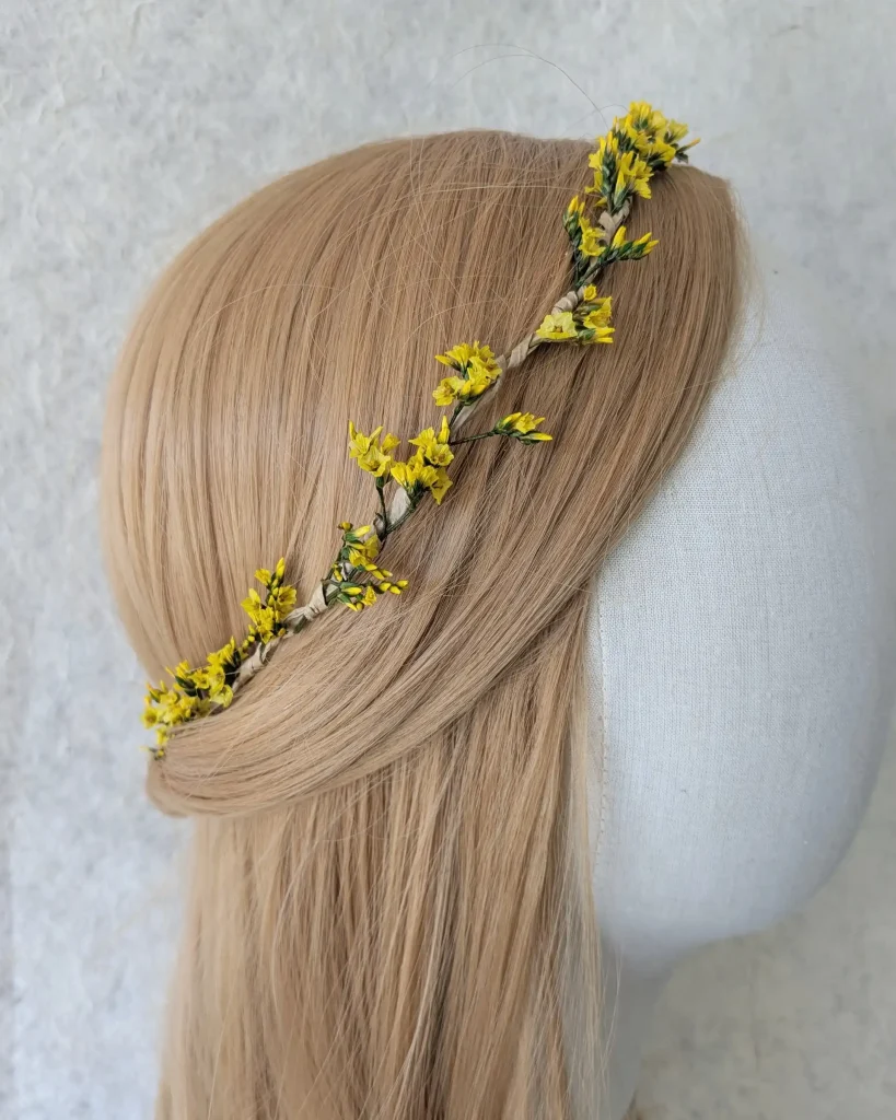 Couronne fine en fleurs séchées jaunes avec feuillage vert, posée sur un mannequin à la chevelure blonde – Les pensées de Lily