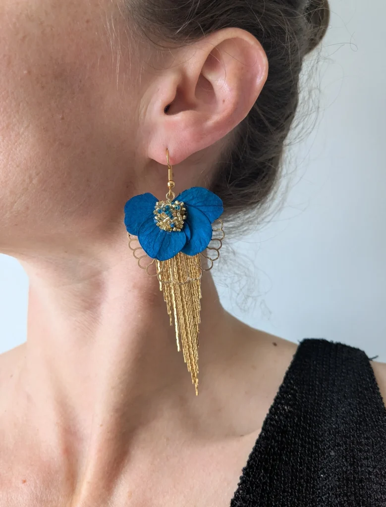 Boucles d’oreilles pendantes bleu roi en fleurs séchées avec perles dorées portées sur oreille – Les pensées de Lily