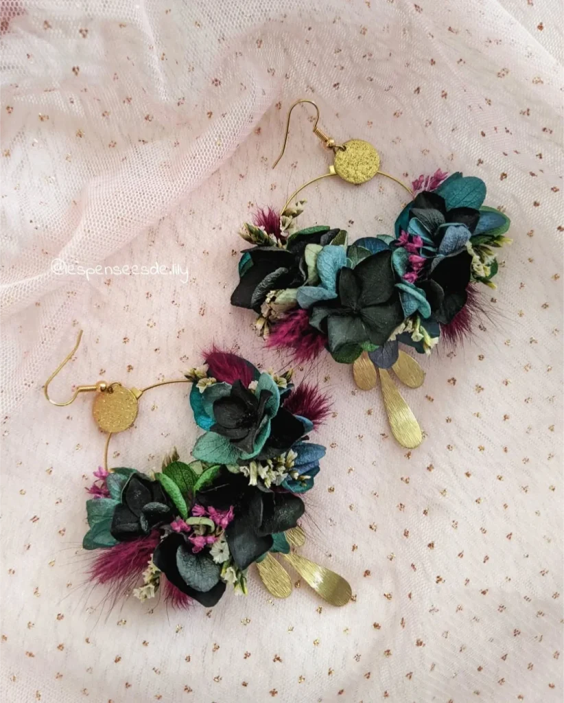Boucles d’oreilles en hortensia noir et bleu, feuillage vert, fleurs bordeaux et pampilles dorées sur tissu rose poudré - Les pensées de Lily