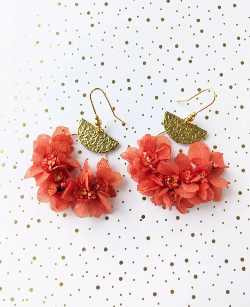 Boucles d’oreilles en fleurs séchées rouge coquelicot avec éléments en laiton texturé sur fond à pois dorés - Les pensées de Lily