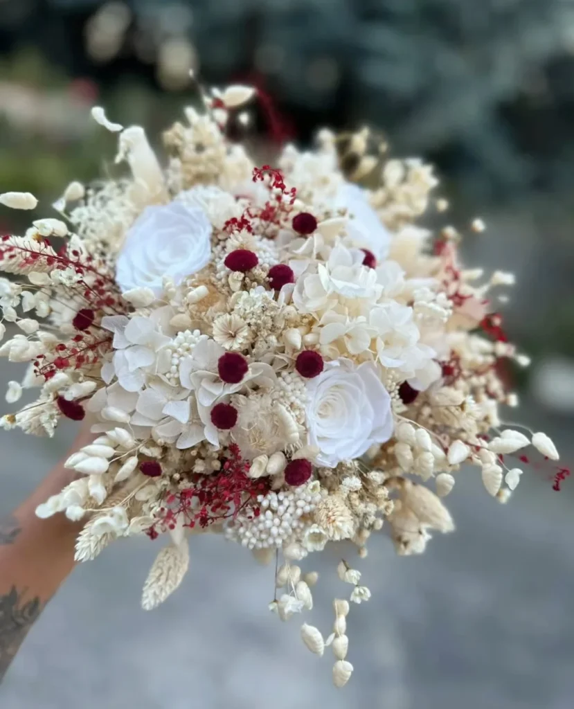 Bouquet de mariée en fleurs séchées blanches avec touches bordeaux et roses stabilisées - Les pensées de Lily