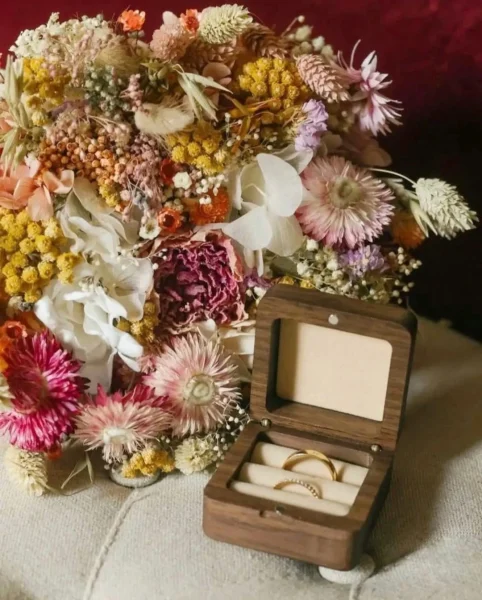 Bouquet de mariage en fleurs séchées multicolores avec un écrin en bois contenant deux alliances dorées - Les pensées de Lily