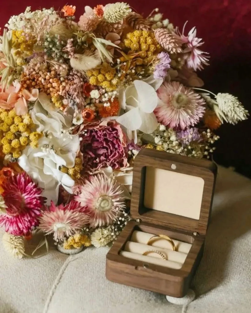 Bouquet de mariage en fleurs séchées multicolores avec un écrin en bois contenant deux alliances dorées - Les pensées de Lily