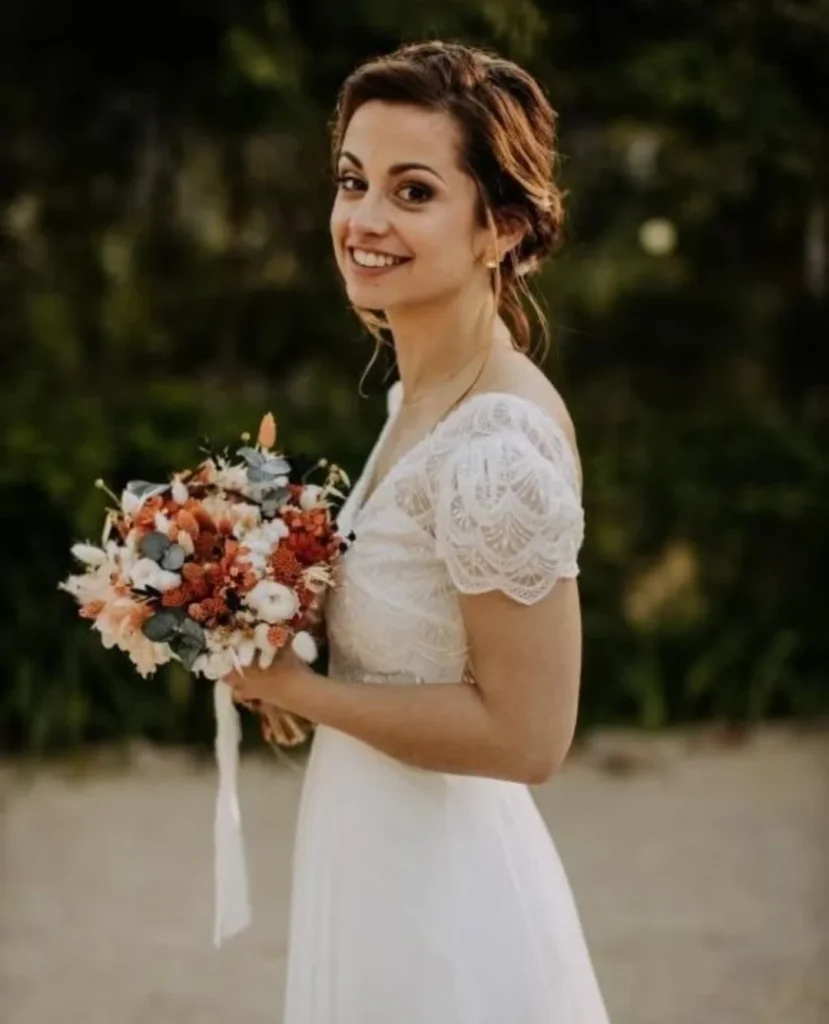 Mariée de profil tenant un bouquet de fleurs séchées avec eucalyptus, blanc et terracotta - Les pensées de Lily
