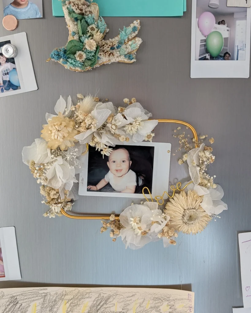 Cadre photo aimanté en fleurs séchées blanc et beige, fixé sur frigo avec une photo au centre - Les pensées de Lily