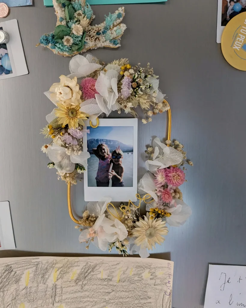 Cadre photo aimanté décoré de fleurs séchées blanc, rose, jaune et violet, fixé sur frigo avec photo au centre - Les pensées de Lily