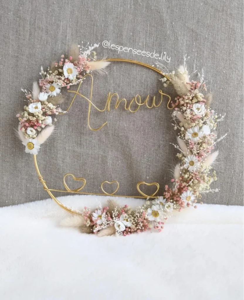Couronne murale mot Amour en fil doré, décorée de fleurs séchées blanches, touches roses et trois cœurs en fil métallique - Les pensées de Lily