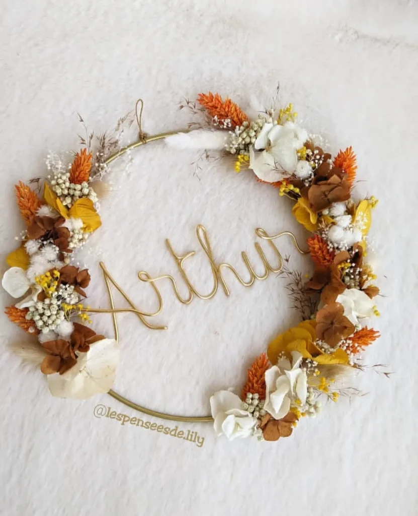 Couronne prénom Arthur en fil doré, ornée de fleurs séchées blanches, moutarde, orange et feuillage brun doré - Les pensées de Lily