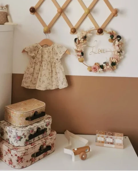 Couronne murale prénom Lou accrochée dans une chambre d’enfant, décorée de fleurs séchées roses, blanches et feuillage vert foncé - Les pensées de Lily