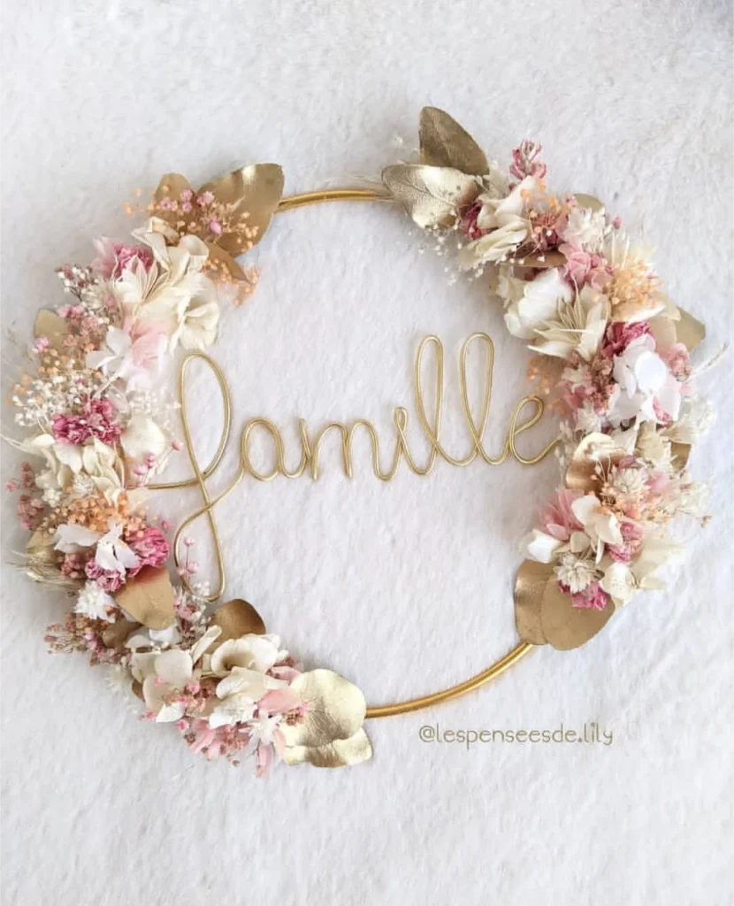 Couronne murale mot Famille en fil doré, ornée de fleurs séchées blanches et roses avec feuilles dorées - Les pensées de Lily