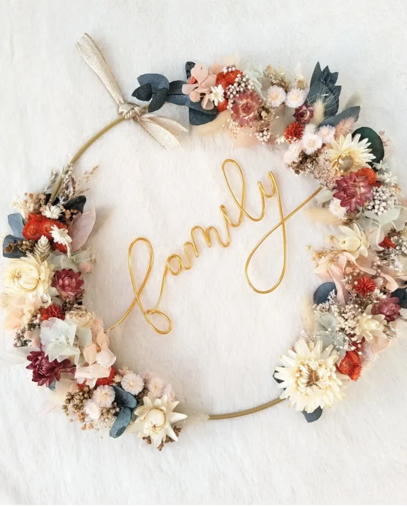 Couronne murale en fleurs séchées aux teintes chaudes avec inscription “family” en fil doré – Les pensées de Lily