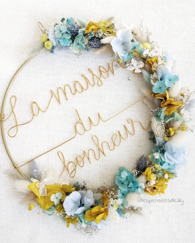 Couronne murale décorative en fleurs séchées jaunes et bleues avec message La maison du bonheur en fil doré - Les pensées de Lily