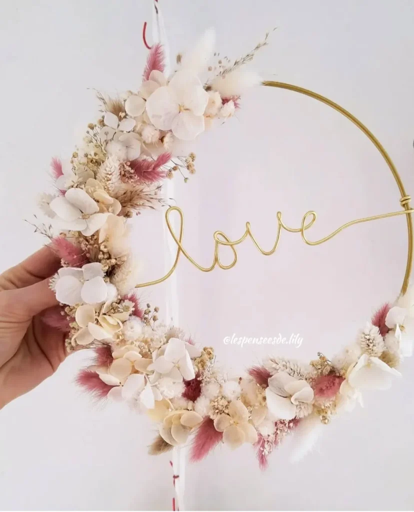 Couronne murale en fleurs séchées et fil doré formant le mot “love” – Les pensées de Lily