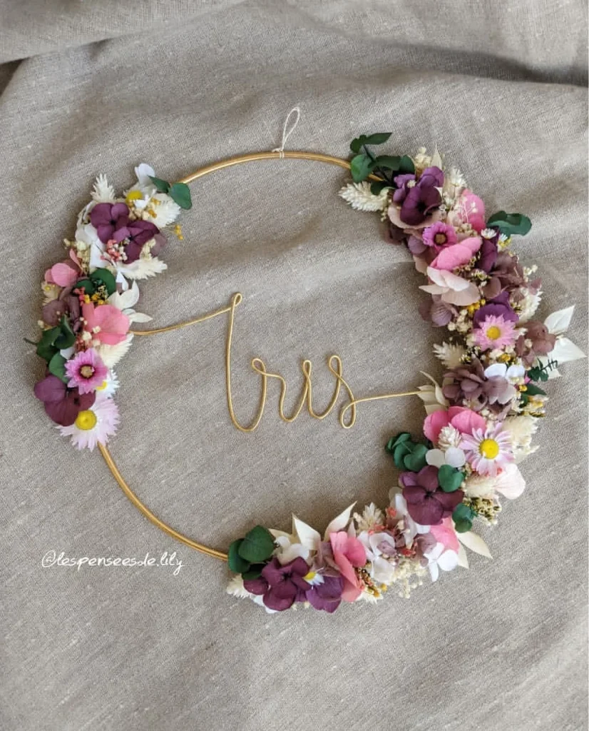Couronne murale avec le prénom Iris en fil doré, décorée de fleurs séchées violettes, roses, blanches et eucalyptus sur fond en lin - Les pensées de Lily