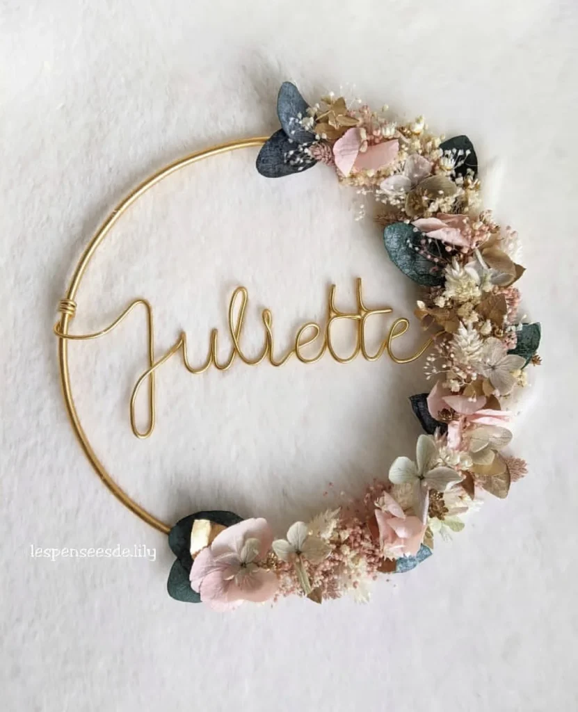 Couronne murale personnalisée avec le prénom Juliette en fil doré, fleurs séchées pastel et eucalyptus sur fond blanc doux - Les pensées de Lily
