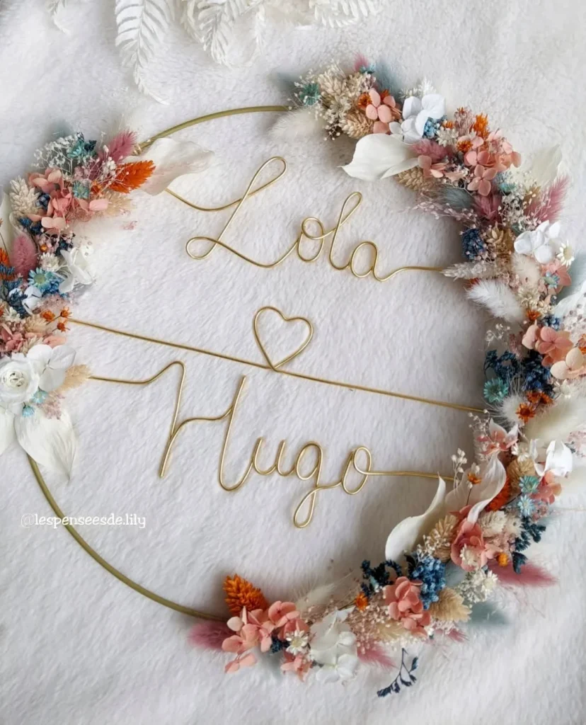 Couronne murale en fleurs séchées avec prénoms en fil doré "Lola" et "Hugo" séparés par un cœur – Les pensées de Lily