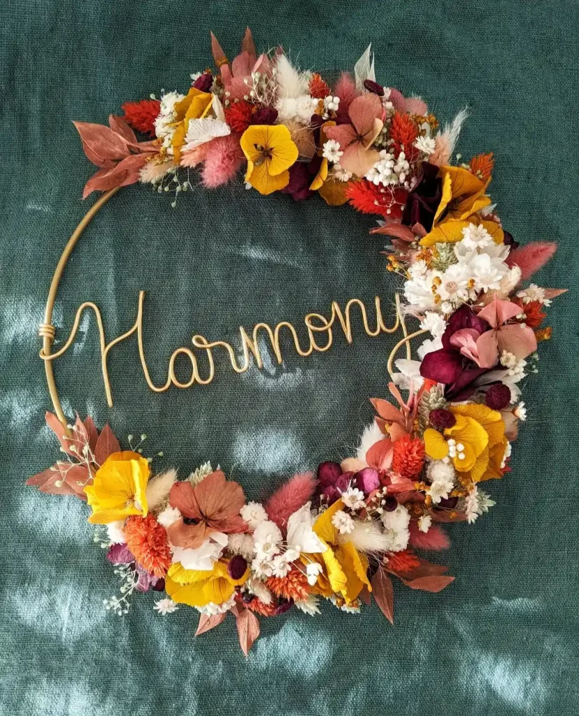 Couronne murale personnalisée en fleurs séchées aux couleurs automnales avec prénom Harmony en fil doré - Les pensées de Lily