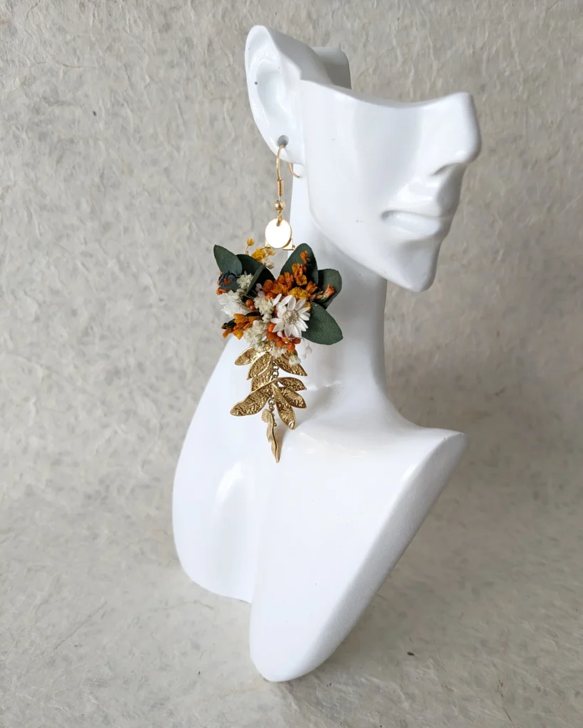 Boucles d’oreilles terracotta avec fleurs séchées et feuillage doré sur présentoir blanc - Les pensées de Lily