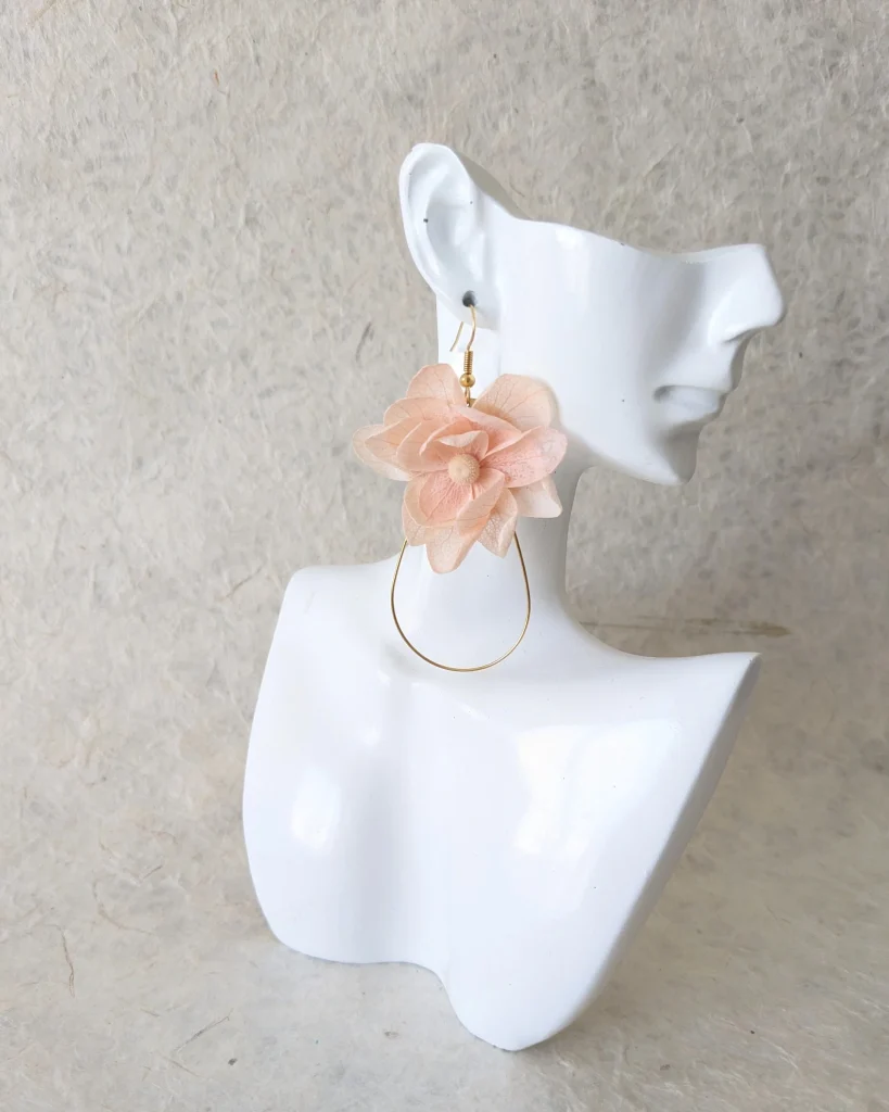Boucles d’oreilles en fleurs séchées rose poudré, sur présentoir