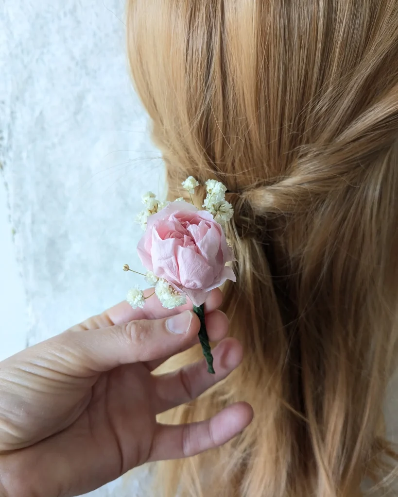 Pique à cheveux en fleurs séchées rose stabilisée, tenue en main